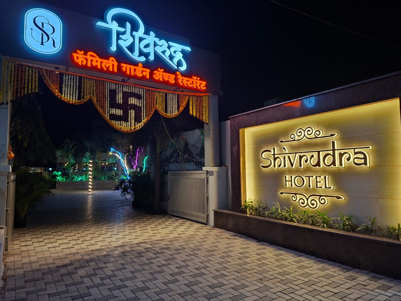Shivrudra Hotel Lohgaon - Wagholi Rd, Lohegaon, Pune, Maharashtra 411047 entrance gate and illuminated signage at night near Pune Airport