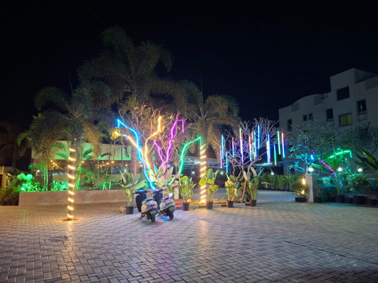Shivrudra Hotel Lohgaon - Wagholi Rd, Lohegaon, Pune, Maharashtra 411047 lawn and parking area illuminated at night