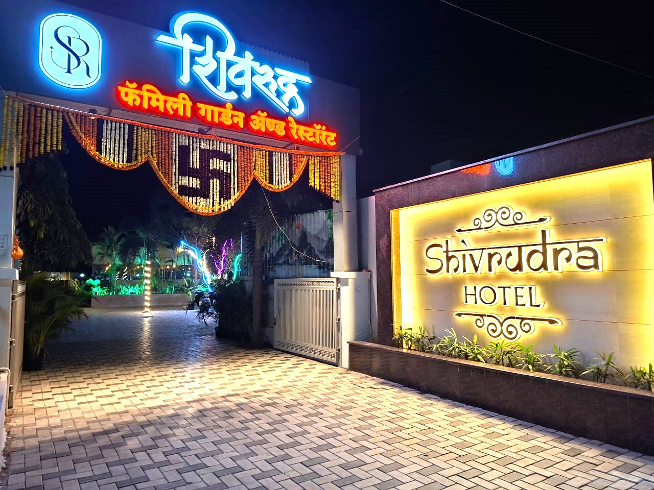 Shivrudra Hotel illuminated entrance at night, a family garden restaurant and hotel near Pune Airport