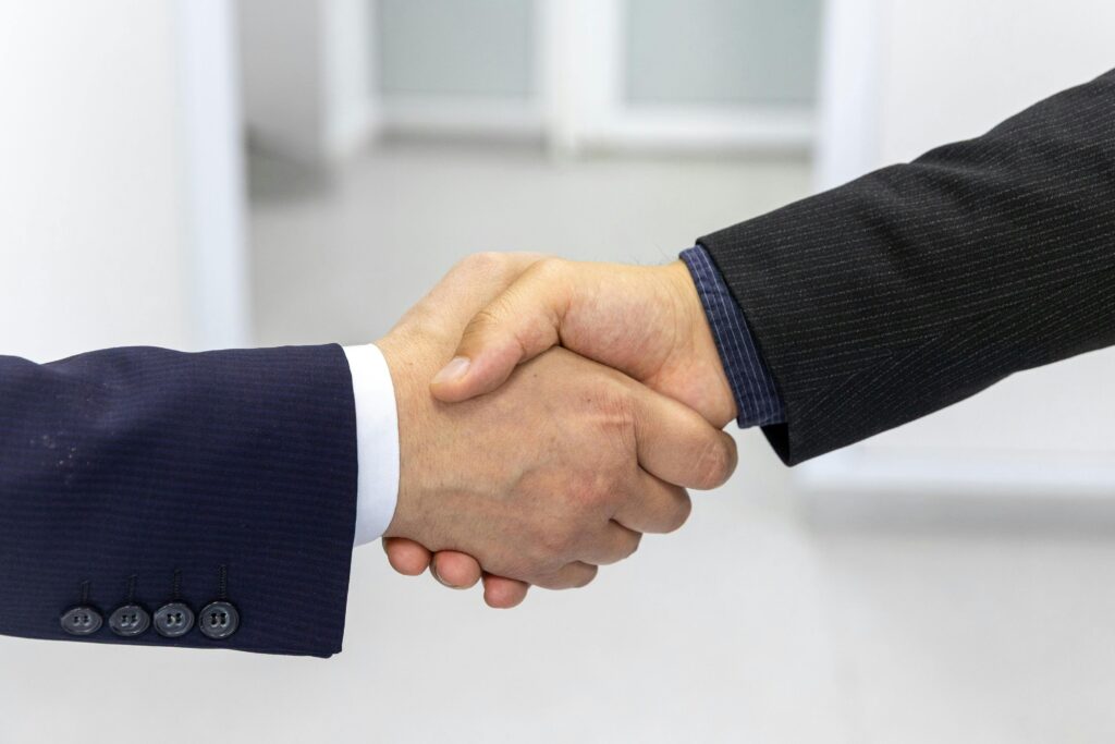 Close-up of a handshake in a business environment, symbolizing partnership.