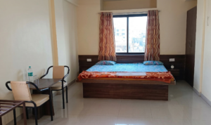 Spacious premium non AC room with double bed and modern ceiling lights at Shivrudra Hotel Lohegaon