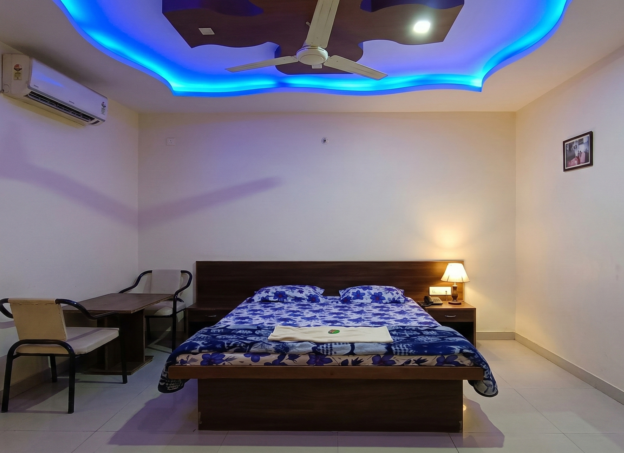Regular AC room with double bed, study table and ceiling lights at Shivrudra Hotel Lohegaon Pune