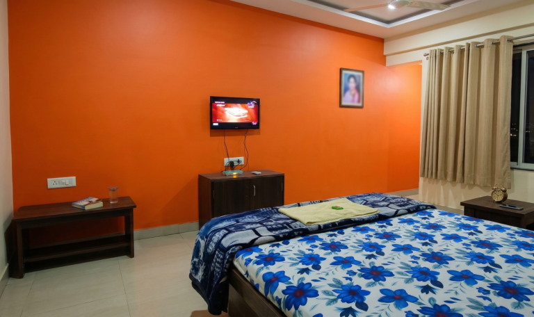 Regular AC room with double bed, study table and ceiling lights at Shivrudra Hotel Lohegaon Pune