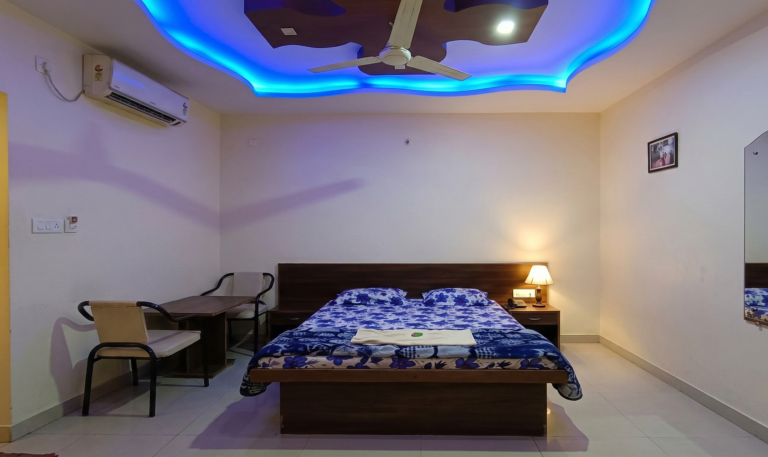 Regular AC room with double bed, study table and ceiling lights at Shivrudra Hotel Lohegaon Pune