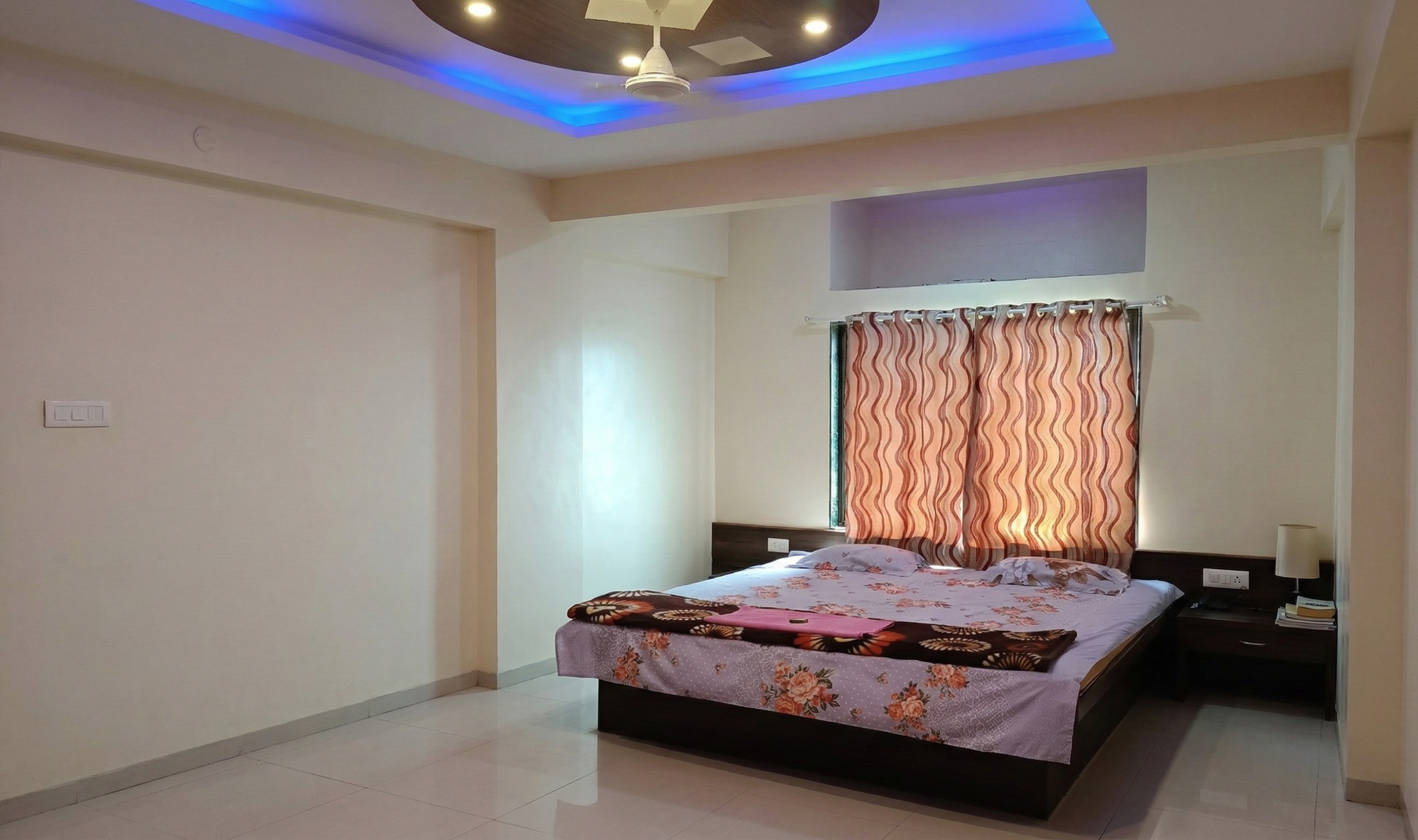 Spacious premium non AC room with double bed and modern ceiling lights at Shivrudra Hotel Lohegaon
