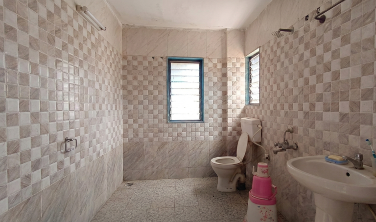 Clean western toilet bathroom with shower in Shivrudra Hotel room Lohegaon Pune